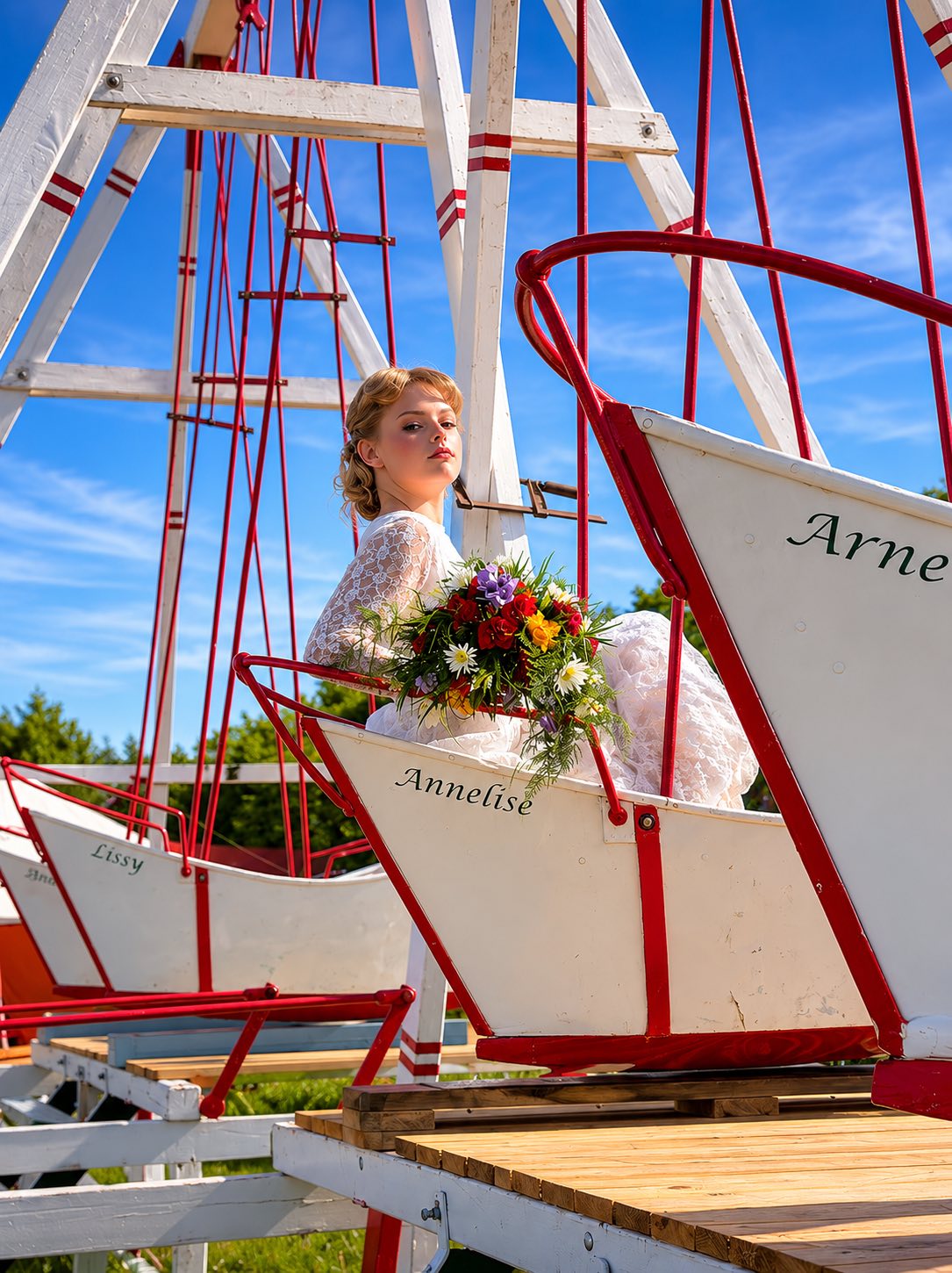 Hvid brud sidder i gyngeforlystelse med en brudebuket bundet med sommerblomster. 
