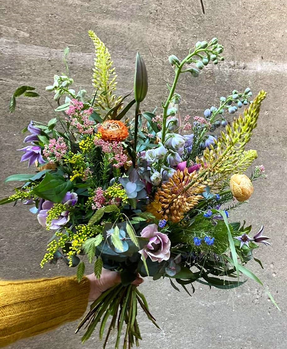 Høj og luftig buket med blomster i årstidens mange farver. 