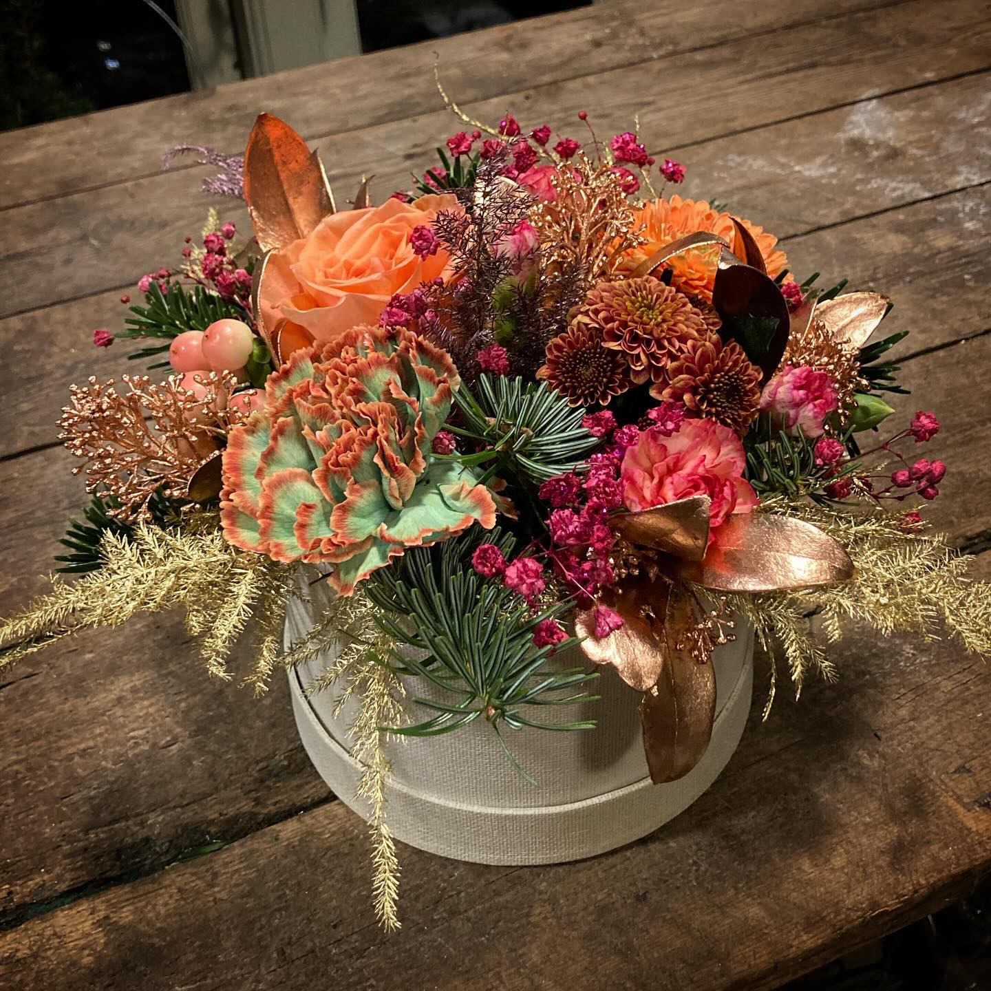 Hatteæske fyldt med farverige blomster og pynt. 