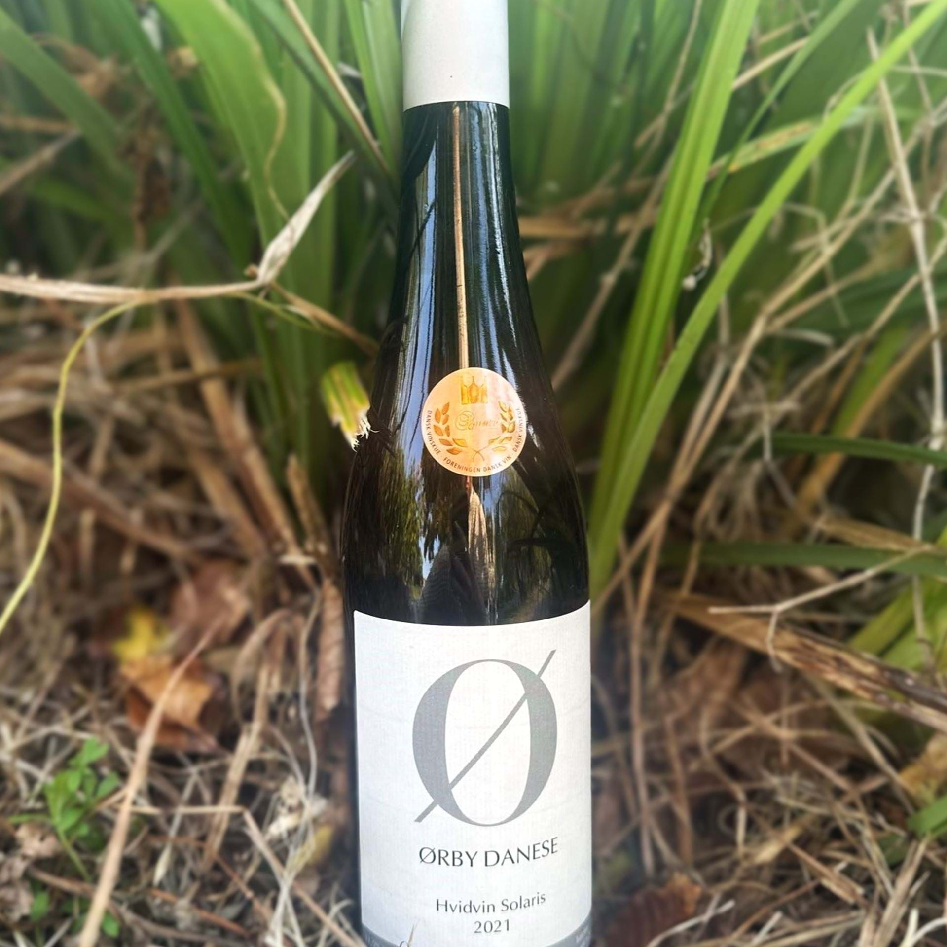 Ørby Danese hvidvin i mørk flaske og med hvid etiket.