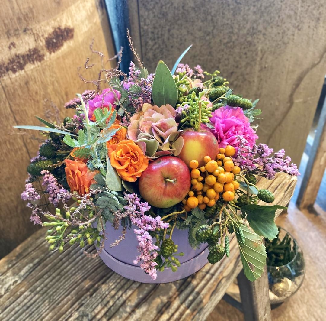 Årstidens smukke hatteæske med friske blomster. 