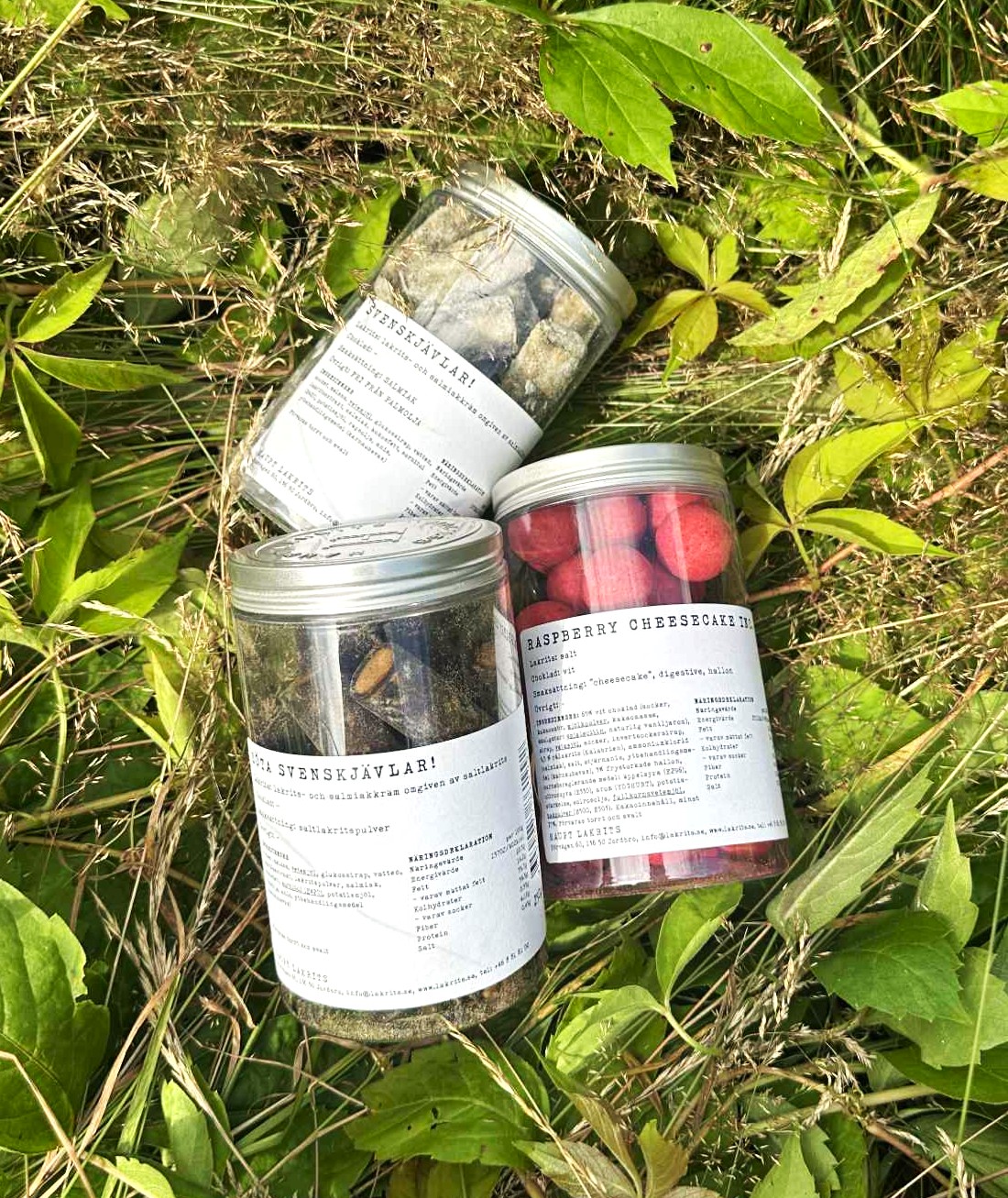 Æsker fra Haupt Lakrits med forskellige smag ligger i græsset. 