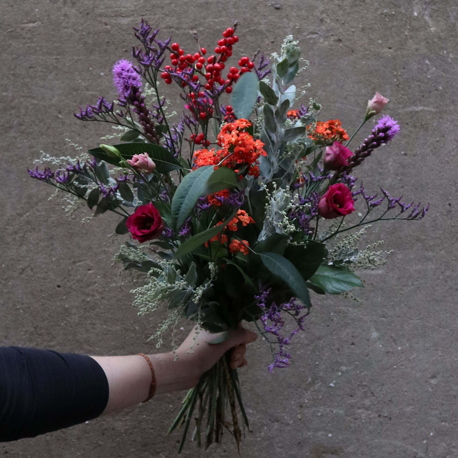 Buket bundet med lilla, blå, røde og orange efterårsblomster.