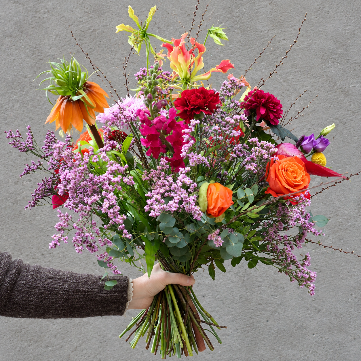 Høj og luftig buket med blomster i årstidens mange farver. 