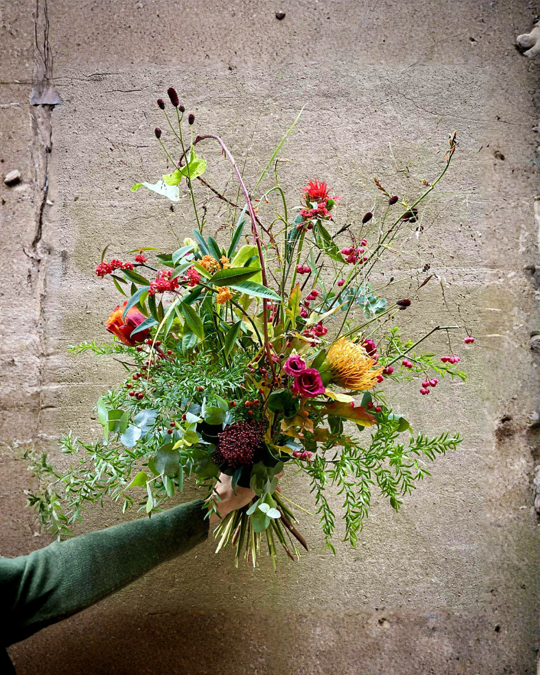 Fyldig og sprudlende buket med blomster i stærke farver.