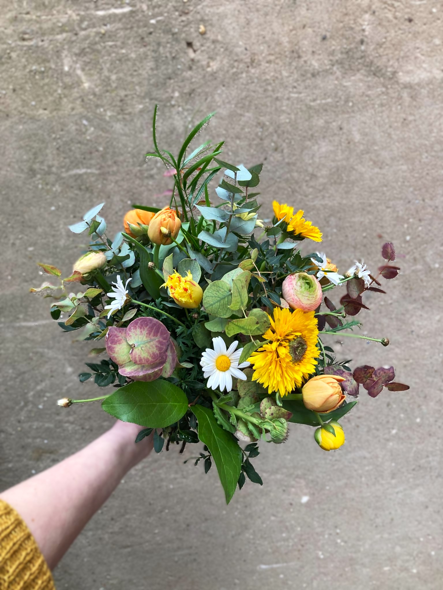Årstidens buket bundet i et sprudende og vildt udtryk med farverige blomster.