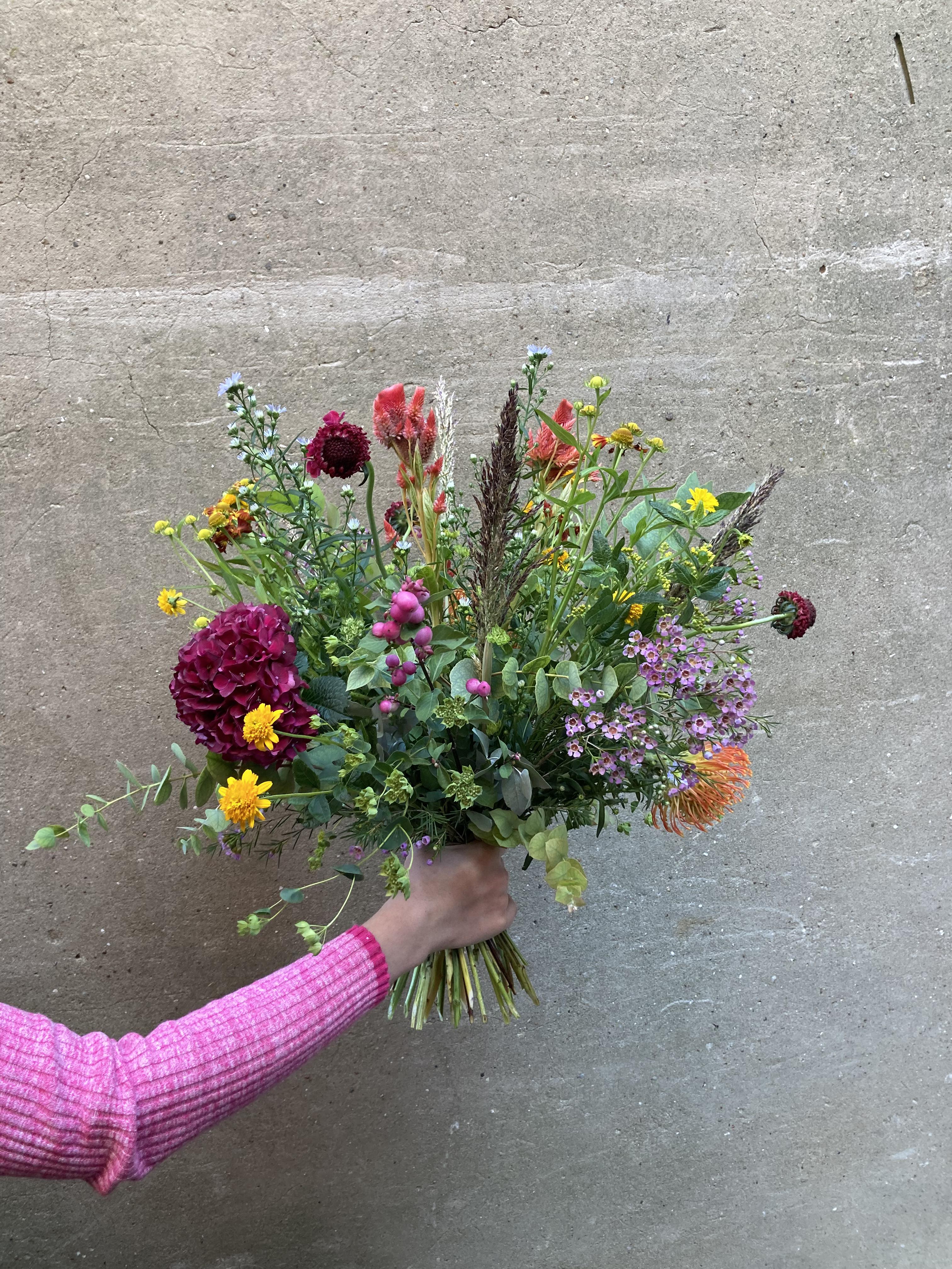 Høj og luftig buket med blomster i årstidens mange farver. 