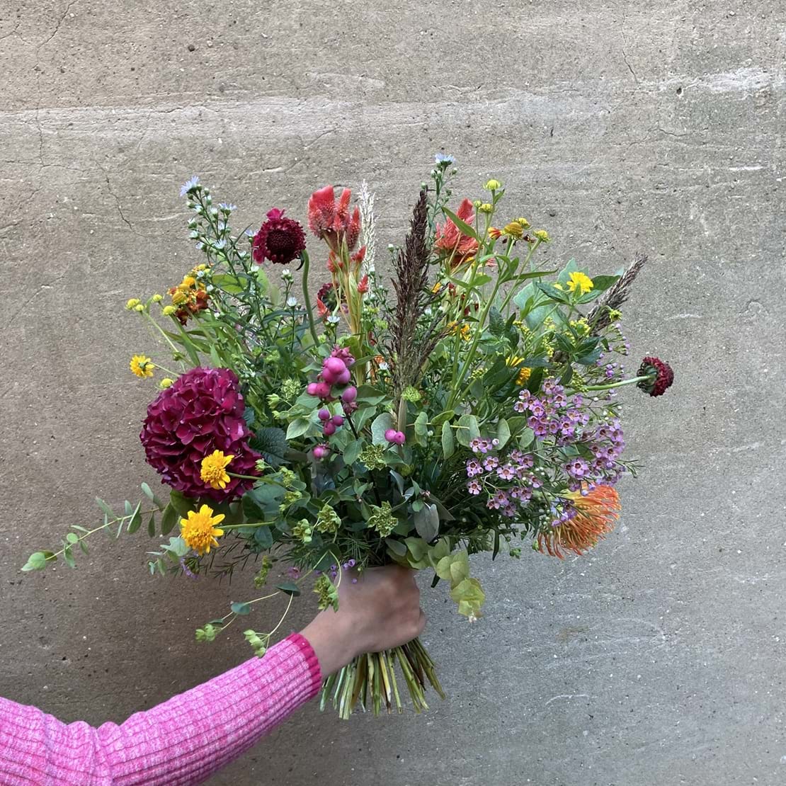 Høj og luftig buket med blomster i årstidens mange farver.
