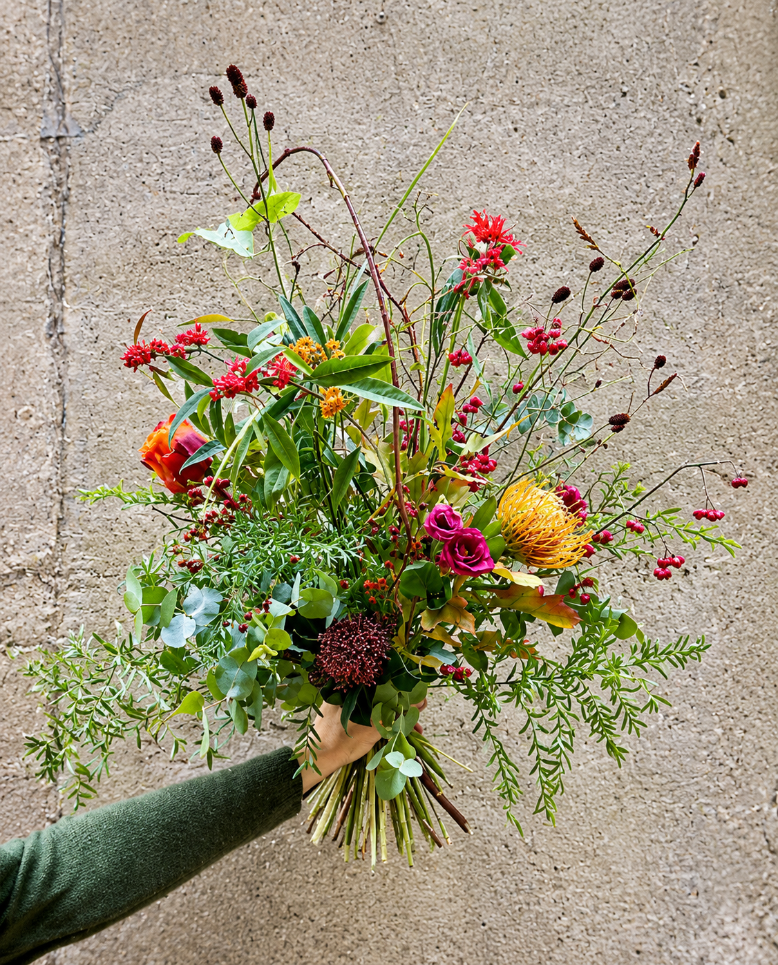 Fyldig og sprudlende buket med blomster i stærke farver.