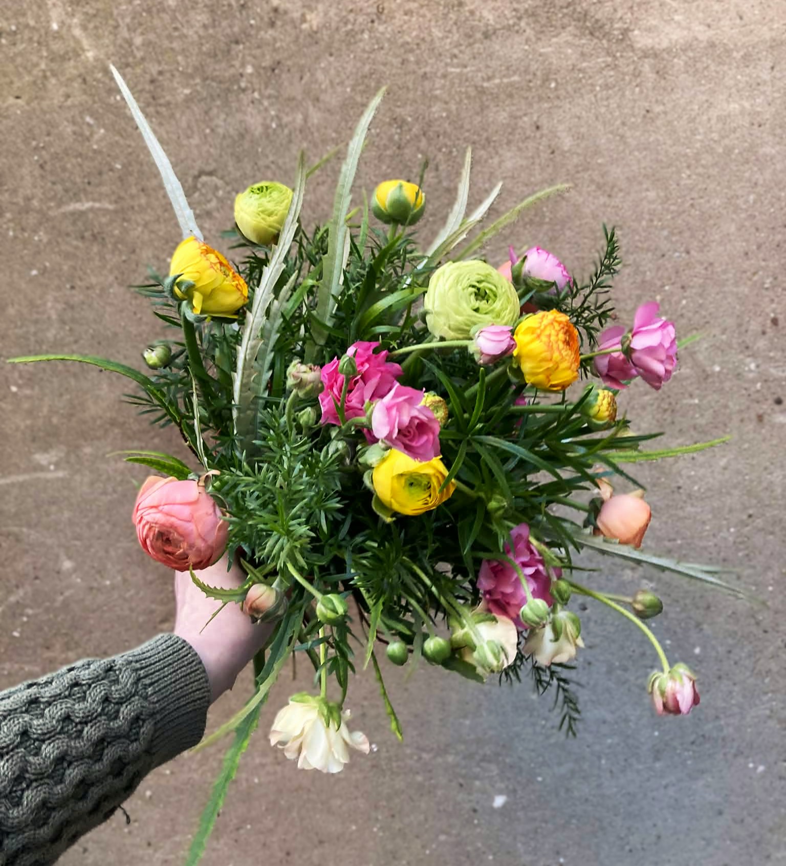 Årstidens buket bundet i et sprudende og vildt udtryk med farverige blomster.