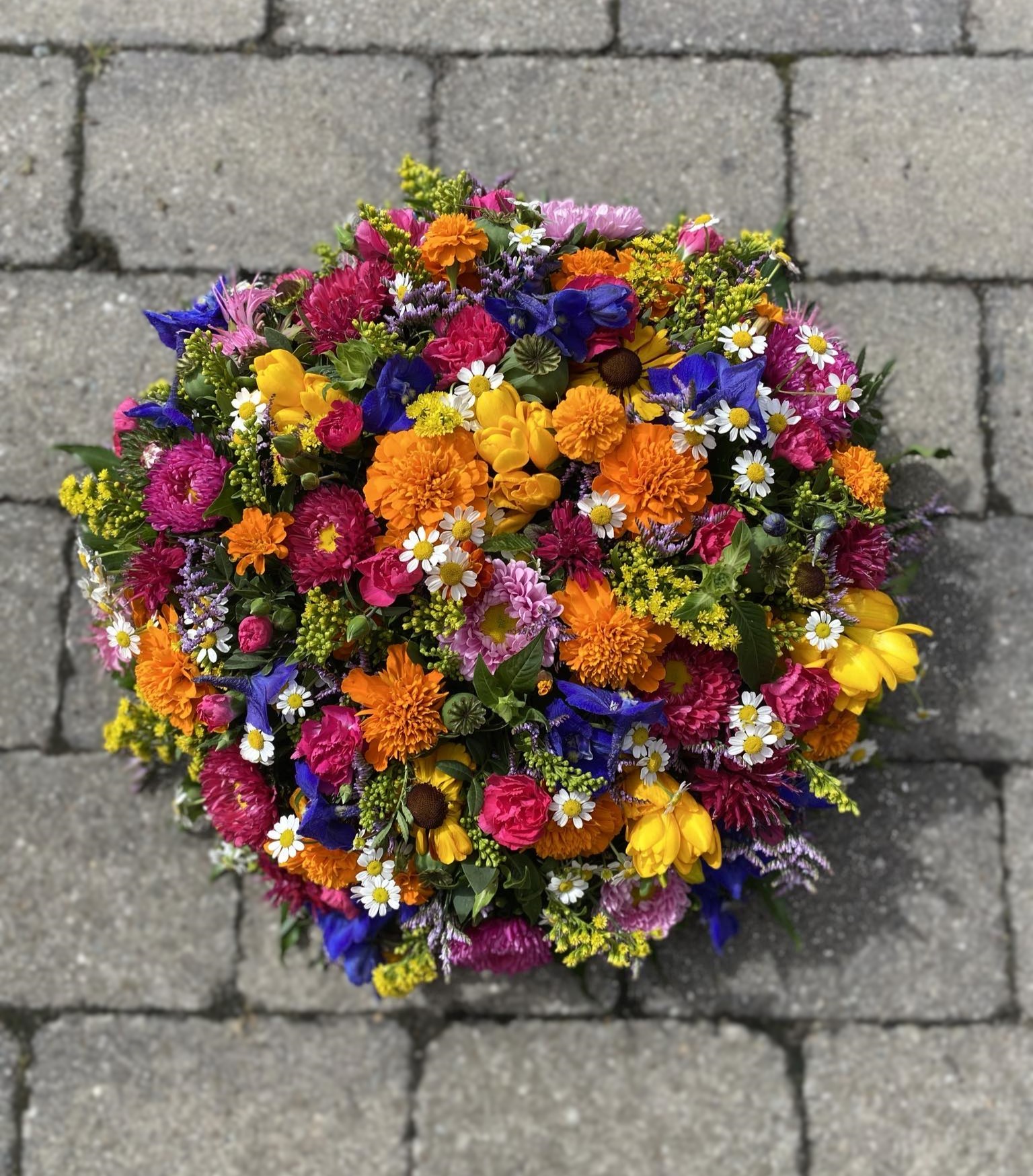 Blomsterpude bundet med blomster i stærke forskellige farver. 