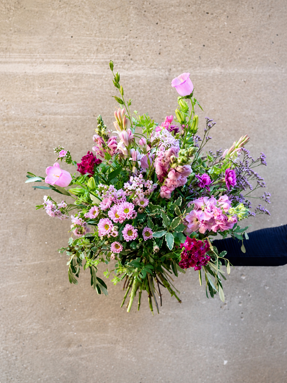Årstidens buket bundet i et sprudende og vildt udtryk med farverige blomster.