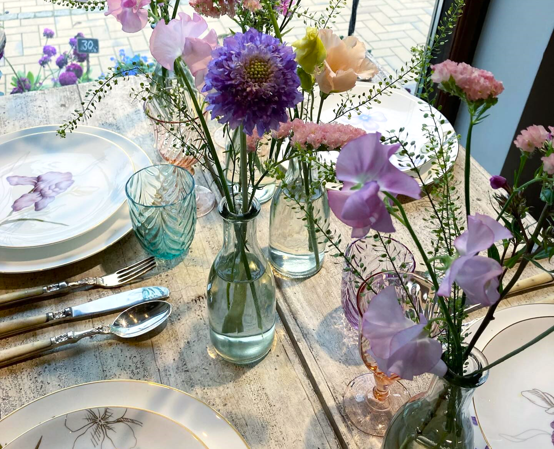Pyntet plankebord med blomstret stel og friske blomster i vaser.
